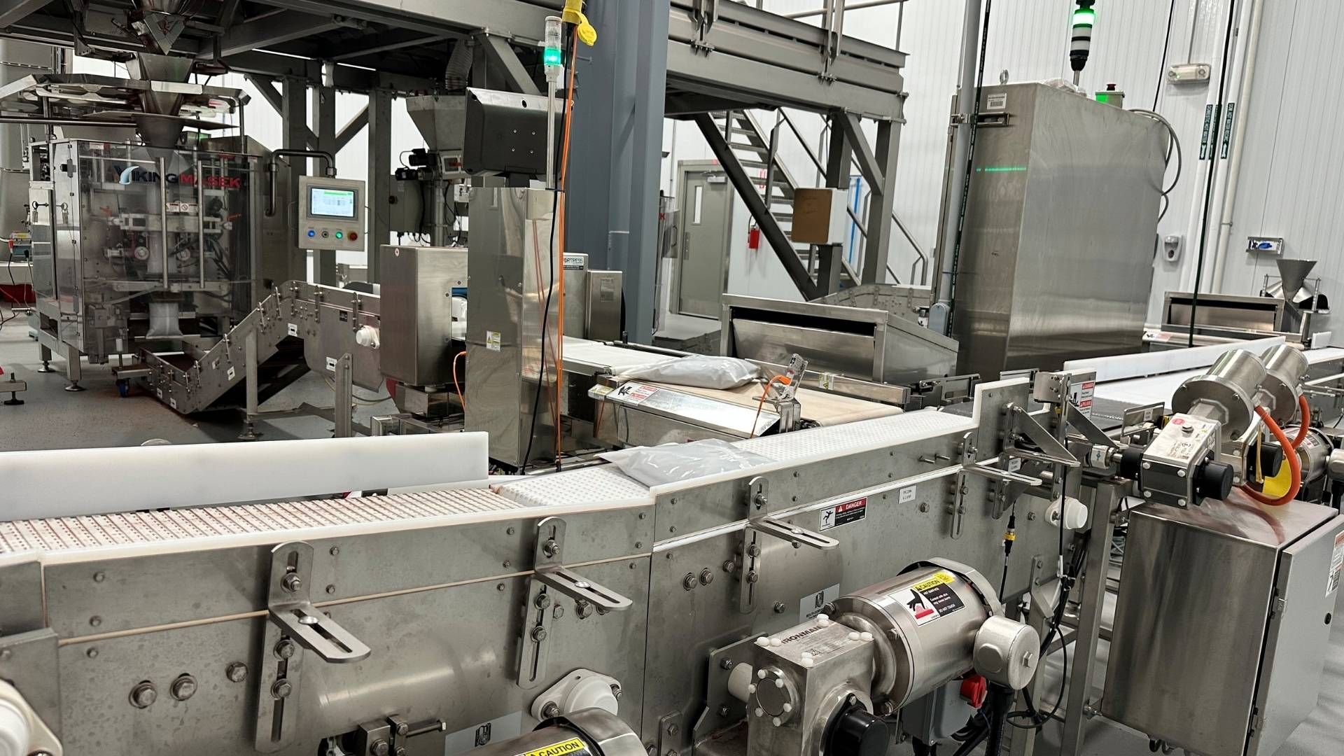conveyor belt with bagged product being transported to packaging room