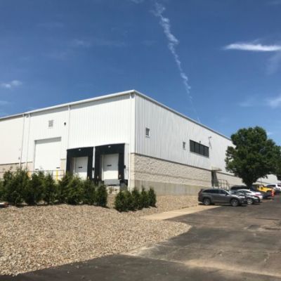 Pre-engineered metal building exterior that features three loading docks employee parking lot