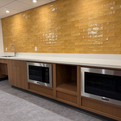 Students in Amstutz Hall can use the snack bar with a sink and microwaves. They golden yellow tile wall provides bold contrast against the white countertops.