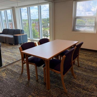 A study lounge includes a full glass wall that separates the study room from the lounge area.