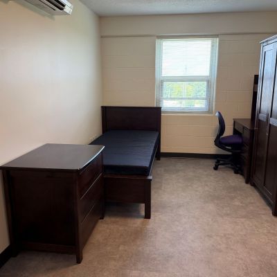 A single dorm room includes one full bed, one dresser, one desk and one closet.