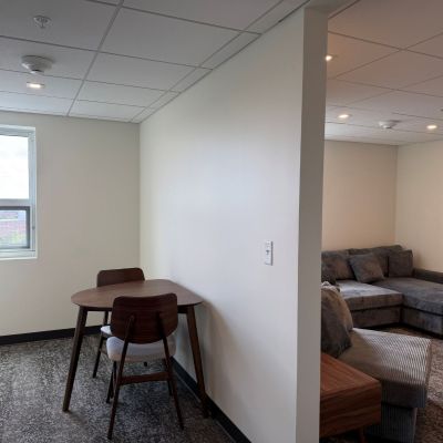 A table and two chairs are in a separate room from the couch and lounge area on the ninth floor of Ashland University Amstutz Hall